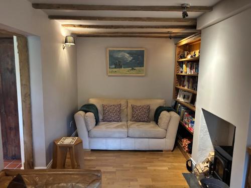 a living room with a couch and a book shelf at Smith Yard Cottage, Ashbourne in Ashbourne