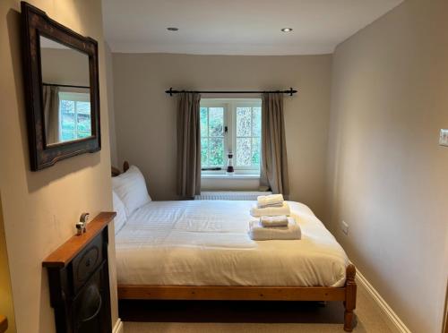 a bedroom with a bed with towels on it at Smith Yard Cottage, Ashbourne in Ashbourne