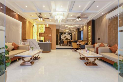 a lobby of a hotel with couches and tables at Hotel Aroma Plaza Delhi Airport in New Delhi
