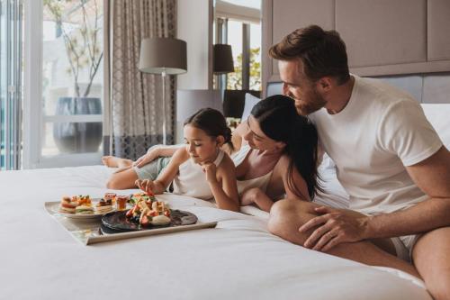 a family sitting on a bed with a plate of food at The St. Regis Mexico City in Mexico City