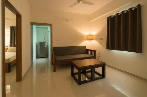 a living room with a couch and a table at HomeSlice Manor, Premium Apartment in Whitefield in Bengaluru