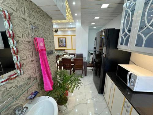 a kitchen with a sink and a dining room at City View Hotel & Apartment in Rājshāhi
