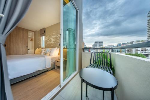 a balcony with a bed and a view of a city at Ralph Poshtel Sukhumvit in Bangkok