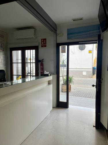 a kitchen with a door leading to a patio at Hostal Al-Andalus in Conil de la Frontera