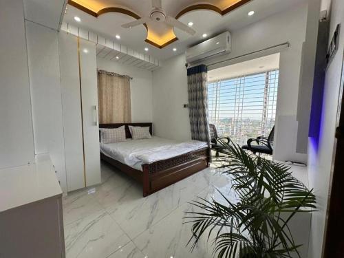 a bedroom with a bed and a large window at City View Hotel & Apartment in Rājshāhi
