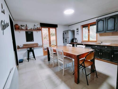 una cucina con tavolo e sedie in legno di La Maison Bleue a Brouvelieures