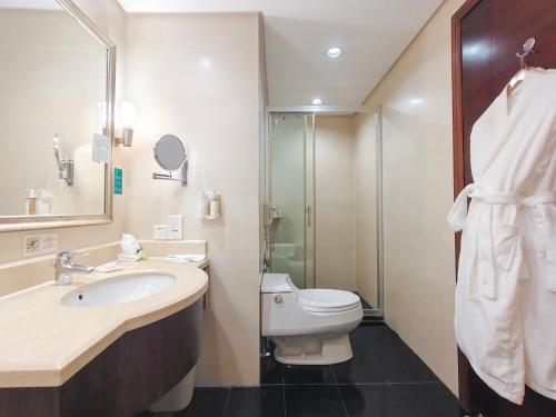 a bathroom with a sink and a toilet and a shower at Holiday Inn Shenzhen Donghua by IHG in Shenzhen