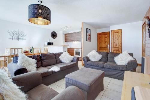 a living room with two couches and a kitchen at Slalom Apartment - Very Town Centre - Snow and Trek - Morzine in Morzine