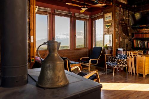 a tea kettle on a table in a room with windows at Kleio in Elatochori