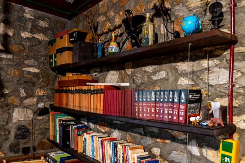 a shelf of books on a stone wall at Kleio in Elatochori