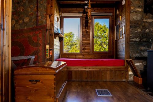 a bedroom with a red bed in a wooden cabin at Kleio in Elatochori
