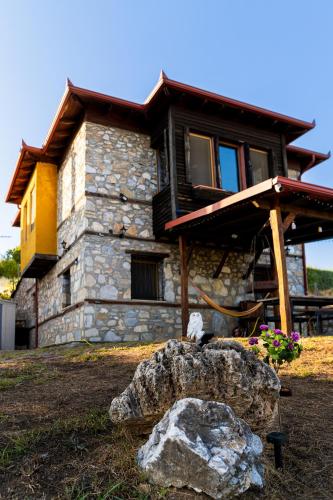 a stone house with a rock in front of it at Kleio in Elatochori