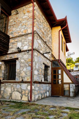 a stone building with a wooden door and a staircase at Kleio in Elatochori