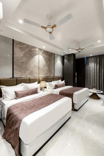 a bedroom with two beds and a ceiling at Hotel Aroma Plaza Delhi Airport in New Delhi