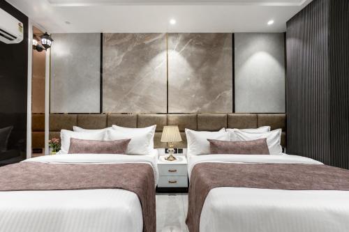 two beds in a hotel room with at Hotel Aroma Plaza Delhi Airport in New Delhi