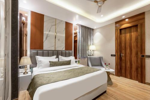 a bedroom with a large bed and a desk at Hotel Aroma Plaza Delhi Airport in New Delhi
