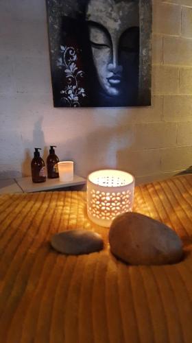 two rocks sitting on top of a bed with a candle at Le Chalet - Maison de vacances in La Roche-en-Ardenne