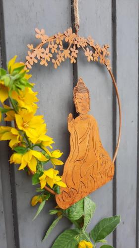 a wooden buddha ornament hanging on a wall at Le Chalet - Maison de vacances in La Roche-en-Ardenne