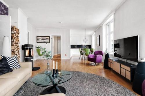 a living room with a couch and a table at Central, lovely apartment with a unique view in Bergen
