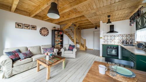 a living room with a couch and a table at Ostoja Bukowo, Sun & Snow in Borowy Młyn