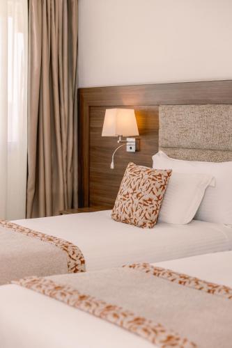 a hotel room with two beds and a lamp at Kenzi Basma in Casablanca