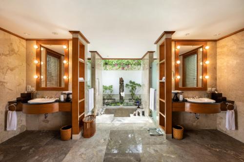 a bathroom with two sinks and a large window at The Oberoi Beach Resort, Bali in Seminyak