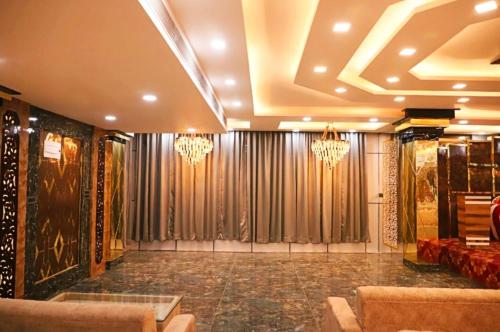 a lobby with chandeliers and a room with chairs and tables at The Vrinda Haritage Siwan in Siwān