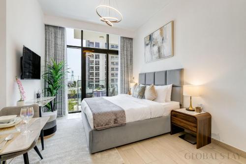 a bedroom with a king sized bed and a table at GLOBALSTAY Azizi Riviera 45 in Dubai