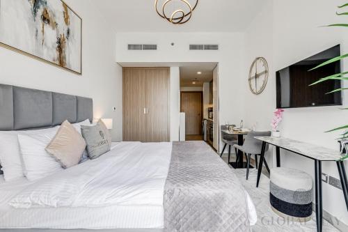 a bedroom with a large white bed and a table at GLOBALSTAY Azizi Riviera 45 in Dubai