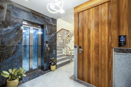 a hallway with a wooden door and stairs at Hotel Aroma Plaza Delhi Airport in New Delhi