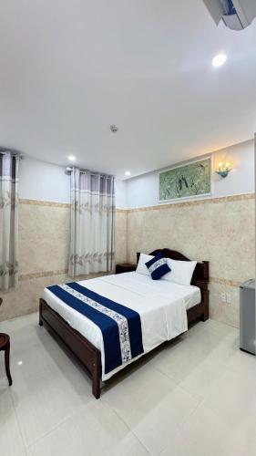 a bedroom with a large bed with blue and white sheets at Victory Hotel 153-155 in Ho Chi Minh City