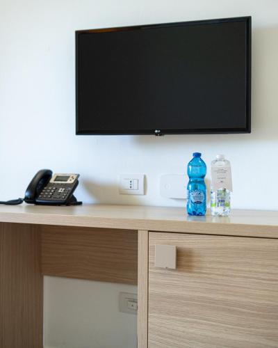 a flat screen tv sitting on top of a desk at Hotel San Teodoro in San Teodoro