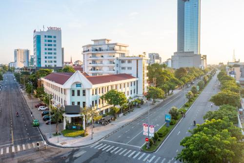 an empty street in a city with tall buildings at ÊMM Hotel Hue in Hue