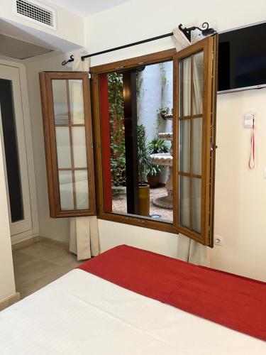 a room with a large window and a red rug at Hostal Al-Andalus in Conil de la Frontera