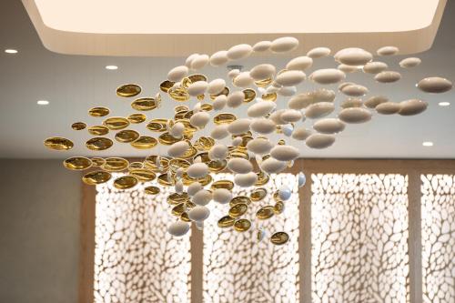 a chandelier with white and gold beads on a ceiling at The Westin Istanbul Nisantasi in Istanbul