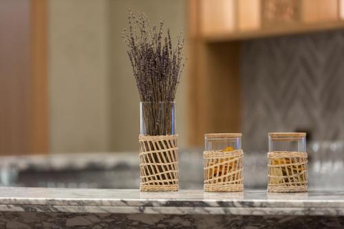 a vase with flowers and three glasses on a table at The Westin Istanbul Nisantasi in Istanbul