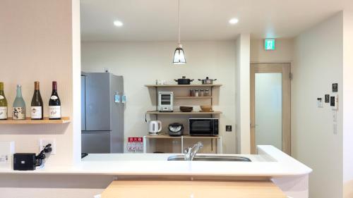 a kitchen with a sink and a refrigerator at The NANAKO in Abiko
