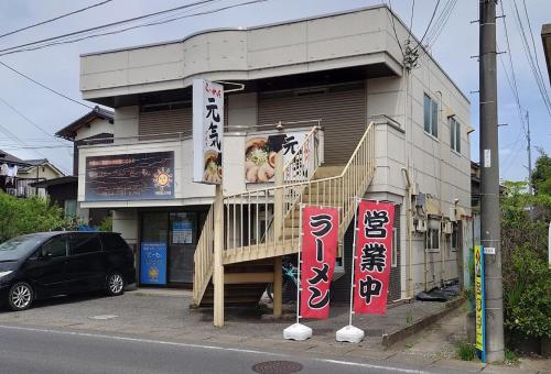 a building with signs on the side of a street at The NANAKO in Abiko