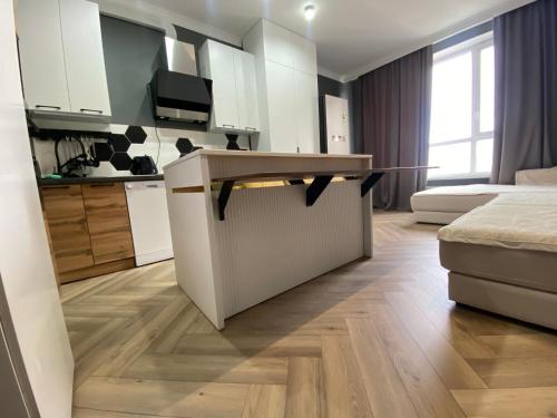 a kitchen and living room with a counter in a room at Новая квартира с 1 спальней в ЖК Nexpo City - район Экспо, торгово-развлекательный центр MEGA Silk Way, Invictus GO, Назарбаев Университет, недалеко Ботанический Сад, аэропорт in Astana