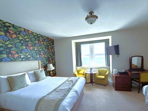 a hotel room with a bed and a window at The Grand Hotel in Torquay