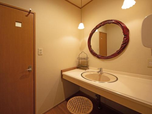a bathroom with a sink and a mirror at Yufuin Onsen Ryokan Hananomai in Yufuin