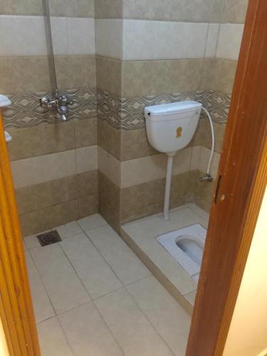 a small bathroom with a toilet in a shower at Al Faisal Hotel in Dargai