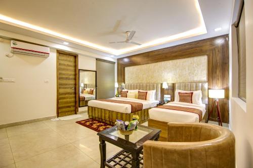a hotel room with two beds and a table at Hotel The Prithvi Near Delhi Airport in New Delhi