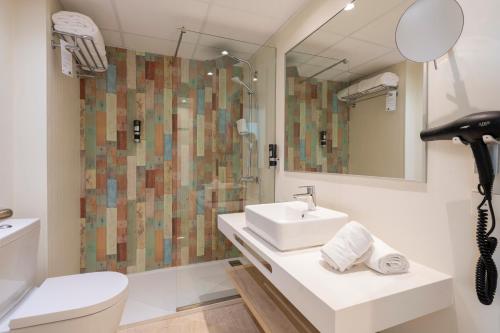 a bathroom with a sink and a shower at Leonardo Royal Hotel Ibiza Santa Eulalia in Es Cana