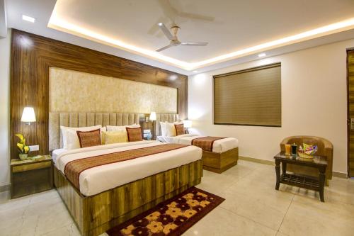 a hotel room with two beds and a table at Hotel The Prithvi Near Delhi Airport in New Delhi