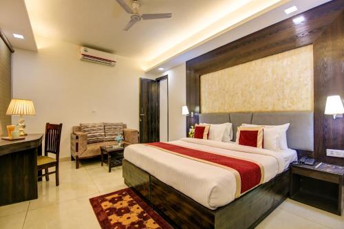a hotel room with a large bed and a desk at Hotel The Prithvi Near Delhi Airport in New Delhi