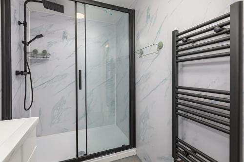 a shower with a glass door in a bathroom at House -Sleeps 8 parking suitable for contractors in Ecclesfield