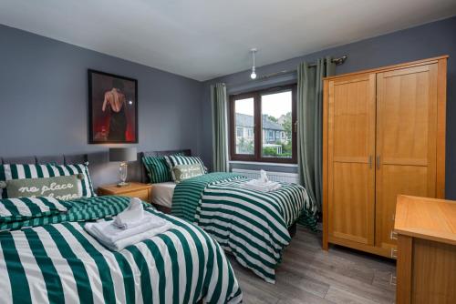 a bedroom with two beds and a couch at House -Sleeps 8 parking suitable for contractors in Ecclesfield