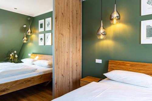 due letti in una camera da letto con pareti e luci verdi di Sommerfrische a Ahrenshoop
