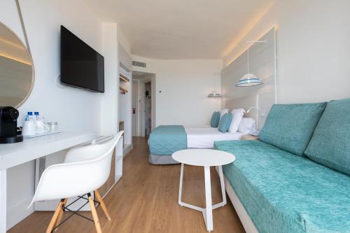 a hotel room with a couch and a bed at Leonardo Royal Hotel Ibiza Santa Eulalia in Es Cana